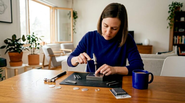 Jewelry maker hand stamping pendant at home