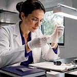 Gemologist inspecting pearl necklace in lab
