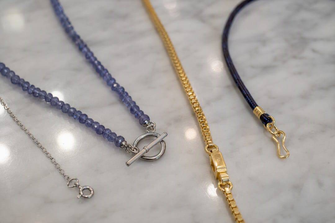 The Necklace Length Guide That Actually Makes Sense Various necklace chains and clasp styles close-up