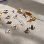Close-up of assorted earring backs on neutral background