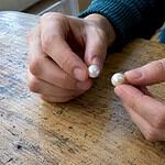Buyer comparing a genuine pearl and shell pearl